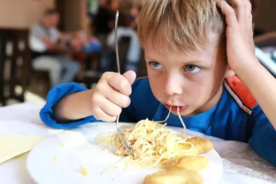 Голодный ребенок ест обед с большим аппетитом Милый мальчик ест макаронные  изделия Стоковое Изображение - изображение насчитывающей младенец, смешно:  112888841