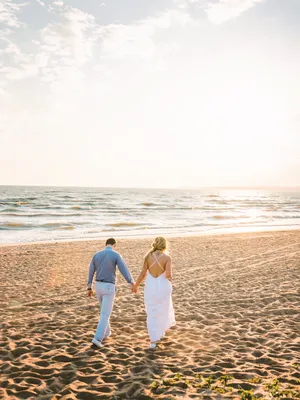 Силуэт пары, стоящей на берегу моря на закате · Бесплатные стоковые фото