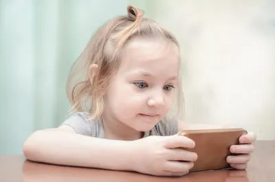 Маленький мальчик с помощью смартфона смотрит на экран ребенок держит  телефон в руках, играет в мобильное устройство, смотрит мультфильмы онлайн  мальчик общается в интернете детская зависимость от гаджетов бессонница |  Премиум Фото