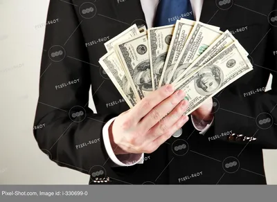 Деловой человек держит много денег на черном фоне :: Стоковая фотография ::  Pixel-Shot Studio