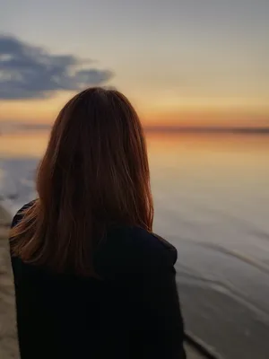 Девушка сидит на берегу моря