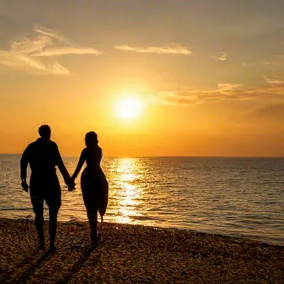 Мужчина и женщина охватывают на берегу спокойствия на море и вид на  расстоянии Стоковое Фото - изображение насчитывающей красивейшее, обнять:  211943250