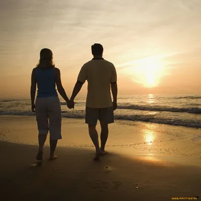 Фото Мужчина и женщина стоят на берегу моря, на фоне заката