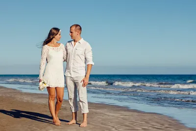 Мужчина и женщина стоят рядом друг с другом на берегу моря · Бесплатные  стоковые фото