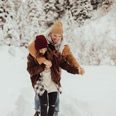 Любящая парочка играет зимой в лесу девушка ездит на парне на фоне  рождественской елки Смейтесь и наслаждайтесь Стоковое Фото - изображение  насчитывающей пуща, любить: 158884762