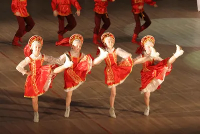 Молодые девушки в красных платьях танцуют русские народные танцы на сцене |  Премиум Фото