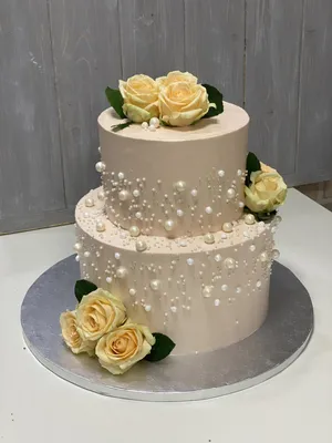 Двухъярусный торт с кремовым покрытием, цветами и ягодами на день рождения,  свадьбу или юбилей