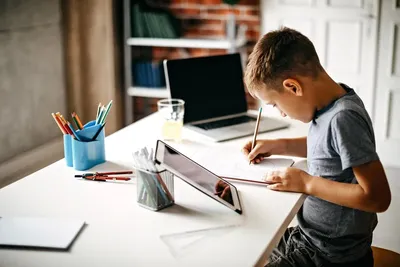 Мальчик делает уроки с ручкой в руке Stock Photo | Adobe Stock